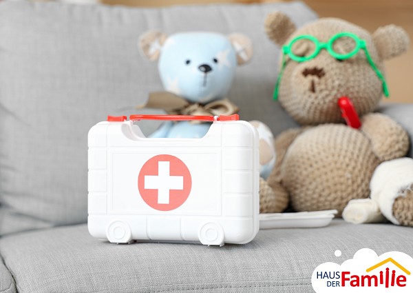 Erste Hilfe Kasten. Zwei Teddyb&auml;ren im Hintergrund