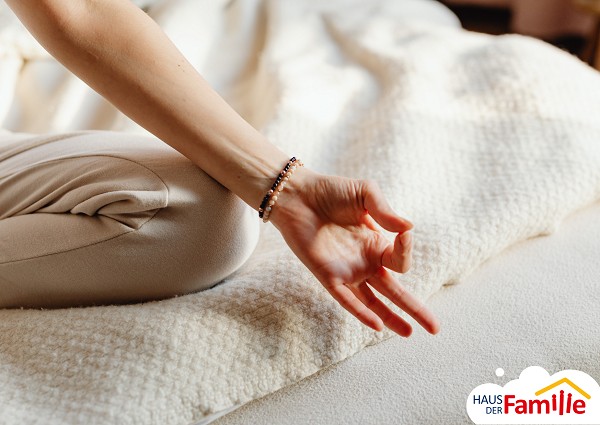 Hand zum Mudra Zeichen geformt auf einem wei&szlig;en Teppich