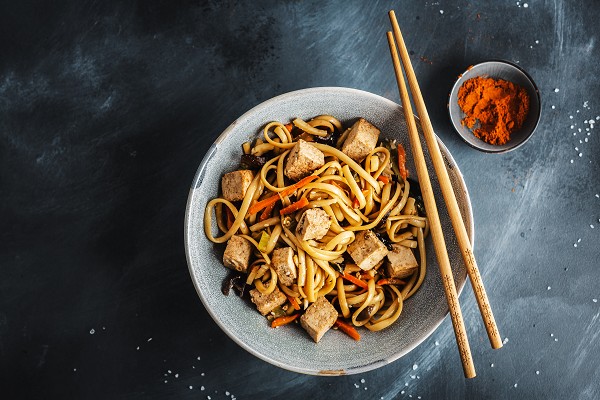 Asia Nudeln mit Tofu in einer Schale aus der Vogelperspektive.