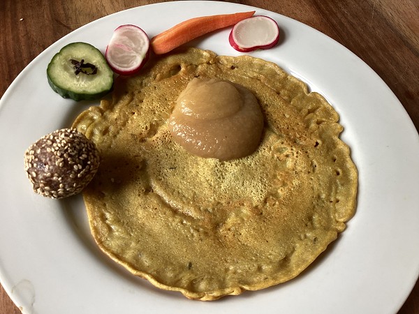 Ein Teller mit Pfannkuchen, Gurke Radieschen, Apfelmus, und einem Energyball