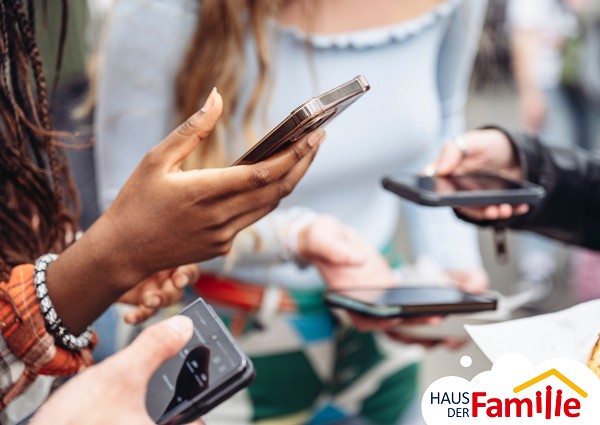 Vier Smartphones die in der Hand gehalten werden