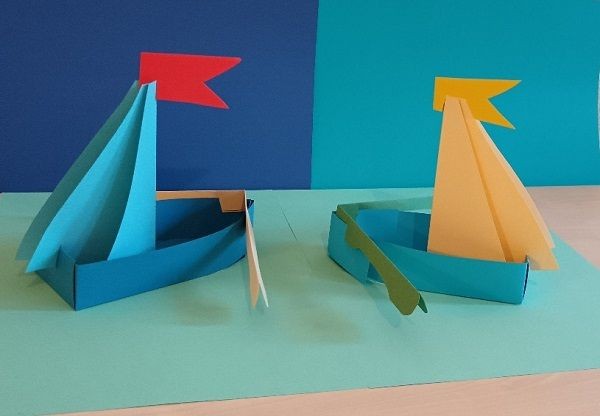 zwei Segelboote vor und auf einem blauen Grund aus Pappe gefaltet