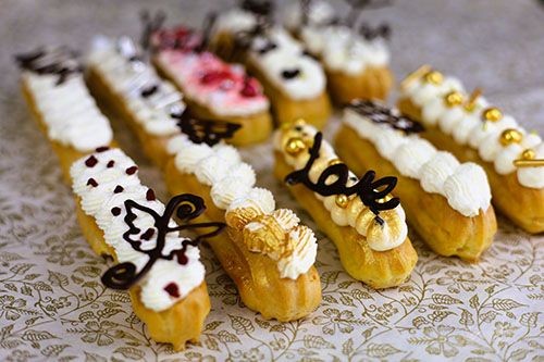 Mehrere Eclairs aufgereiht mit verschiedenen Toppings.