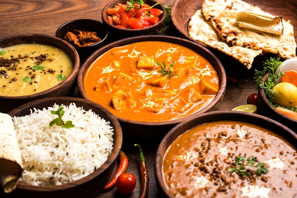 Typisch indische Gerichte in Sch&uuml;sseln mit Naan-Brot