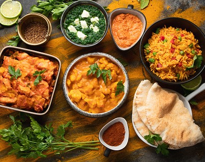 Typisch indisches Essen in Sch&uuml;sseln mit Naan-Brot