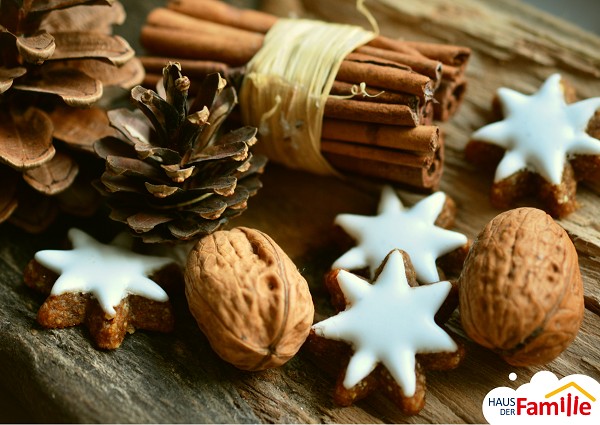 Zimtstangen und Weihnachtsgeb&auml;ck auf einem Holztisch.
