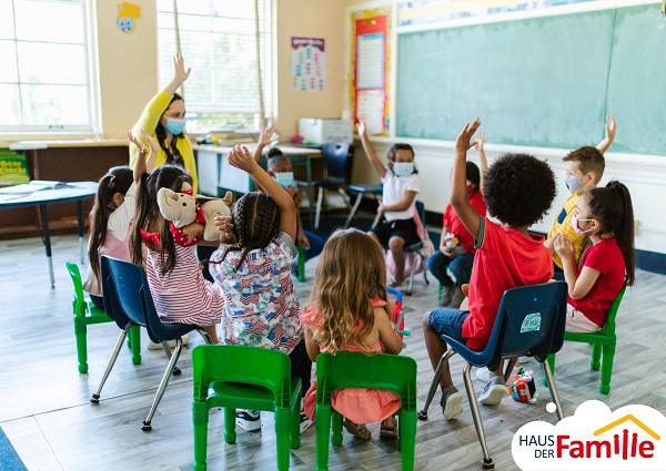 Kinder sitzen im Stuhlkreis